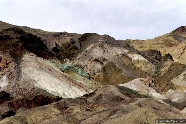 Artist's Palette — the painted hillside in full, its reds, greens, and purples recording volcanic hydrothermal minerals (iron, chlorite, and manganese oxides) locked into the rock.