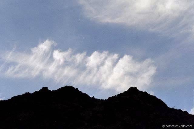 Mountain silhouette under gathering clouds over Death Valley.